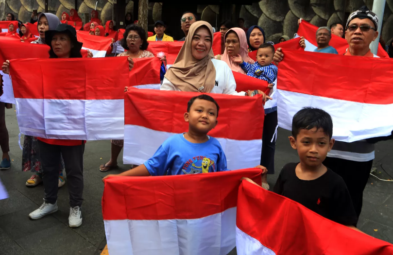 Sejumlah warga membentangkan Bendera Merah Putih.