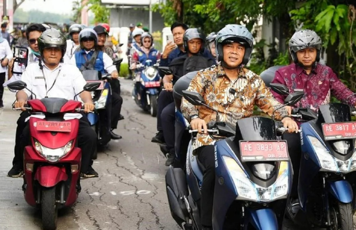 Menteri Kemendukbangga/Kepala BKKBN Wihaji (depan) didampingi Wakil Wali Kota Madiun Bagus Panuntun (kanan) mengendarai sepeda motor saat kegiatan simulasi mekanisme pendistribusian program MBG