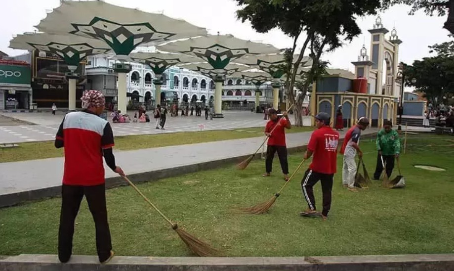 BERSIHKAN: Sejumlah petugas kebersihan saat membersihkan kawasan Alun-Alun Kota Pasuruan.