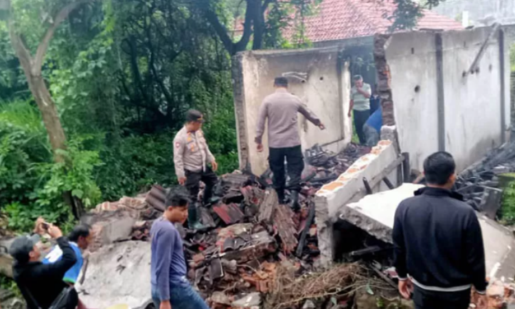 OLAH TKP: Petugas kepolisian saat mengecek rumah yang hangus terbakar. Rumah tersebut kosong, lantaran pemiliknya disebut-sebut tinggal di Surabaya.
