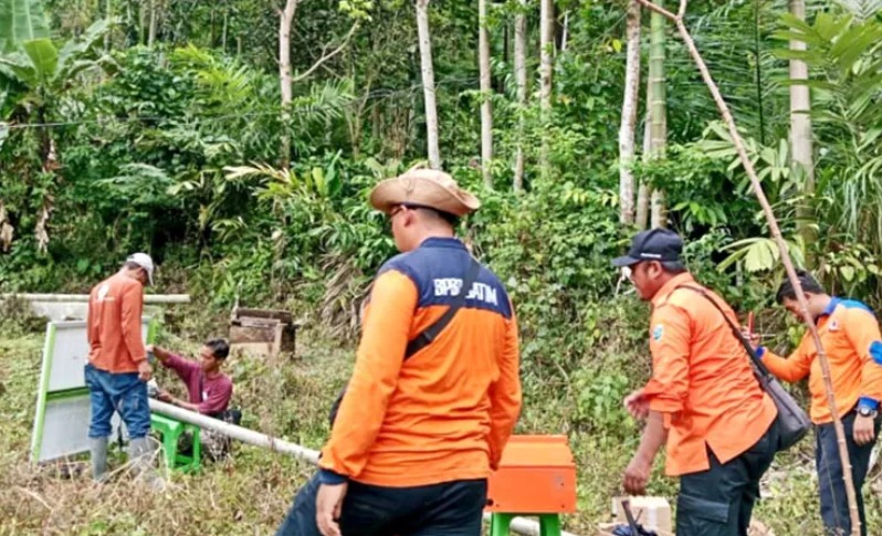 PENCEGAHAN: Personel BPBD memasang early warning system di Dusun Brigaan, Desa Plaosan, Krucil.