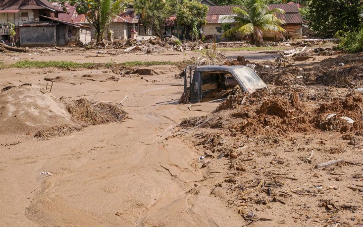 Terlihat mobil tertutup lumpur di terjang banjir bandang susulan beberapa hari lalu yang terjadi di Nagari Batu Busuk, Padang, Jum