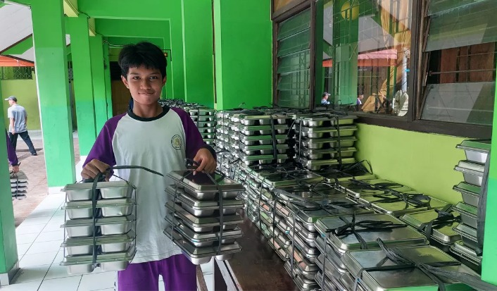 Siswa menenteng ompreng MBG.