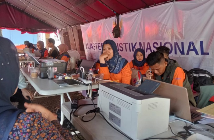 Petugas BNPB di pusat gudang logistik di Bandara Halim Perdanakusuma menerima bantuan kemanusiaan untuk dikirimkan ke lokasi bencana di Sumatera.