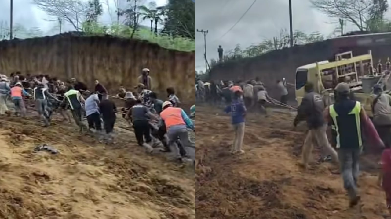 Warga Desa Arul Badak membantu mobil PLN melewati jalan yang rusak saat akan perbaiki listrik.