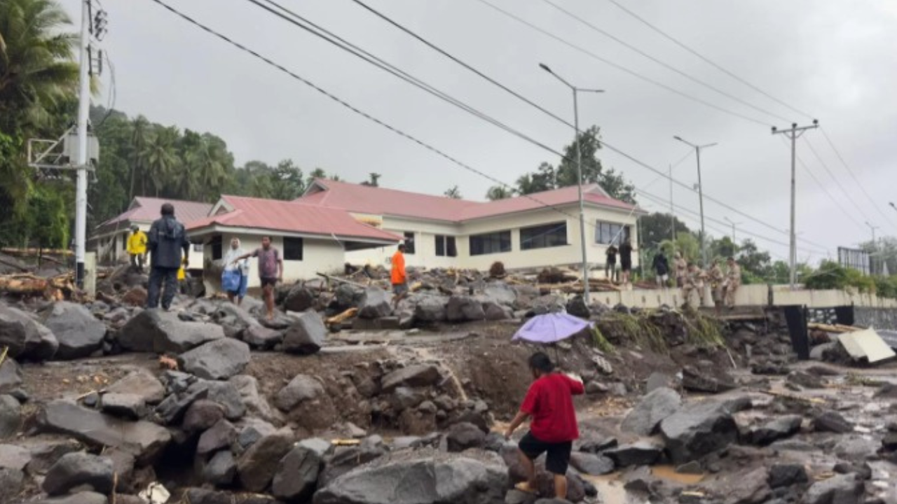 Material batu-batuan memenuhi jalanan pascabanjir bandang yang menerjang 3 kecamatan di di Kabupaten Kepualauan Sitaro pada Senin (5/1).