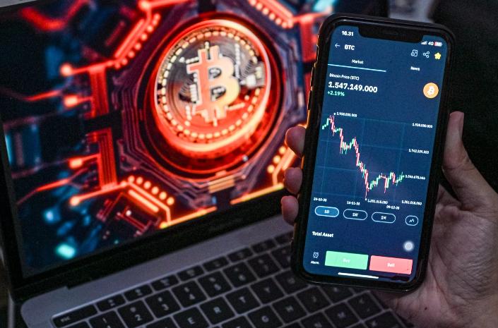 Investor melihat pergerakan kripto Bitcoin melalui handphone di Depok, Jawa Barat, Rabu (10/12/2025). (Salman Toyibi/ Jawa Pos)
