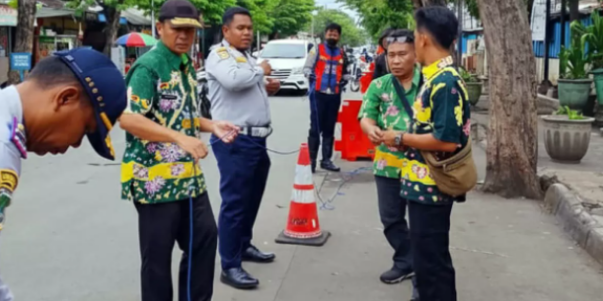 PEMBATAS: Petugas Dishub dan UPT Pasar saat memasang water barrier di depan Pasar Bangil. Hal ini dilakukan, untuk mencegah parkir liar