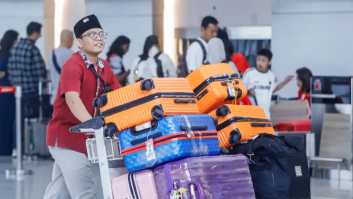 Petugas travel Haji dan Umroh menata koper calon jemaah di Terminal 2 Bandara Internasional Juanda, Jawa Timur, Senin (2/3/2025). (Riana Setiawan/ Jawa Pos)