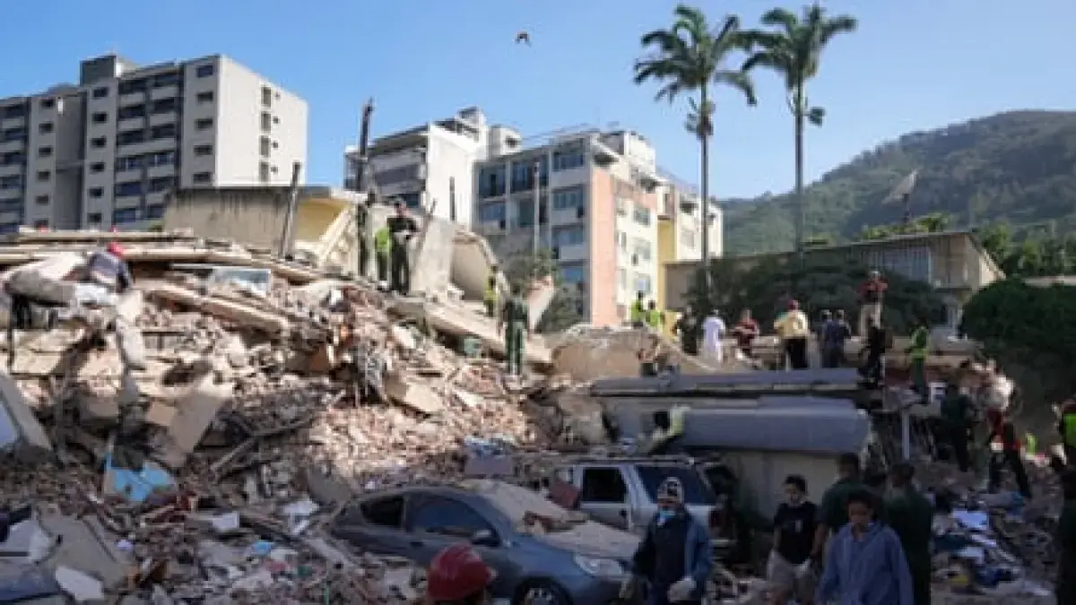 Warga dan petugas penyelamat mencari melalui reruntuhan bangunan yang runtuh di Caracas. (Ariana Cubillos/AP)