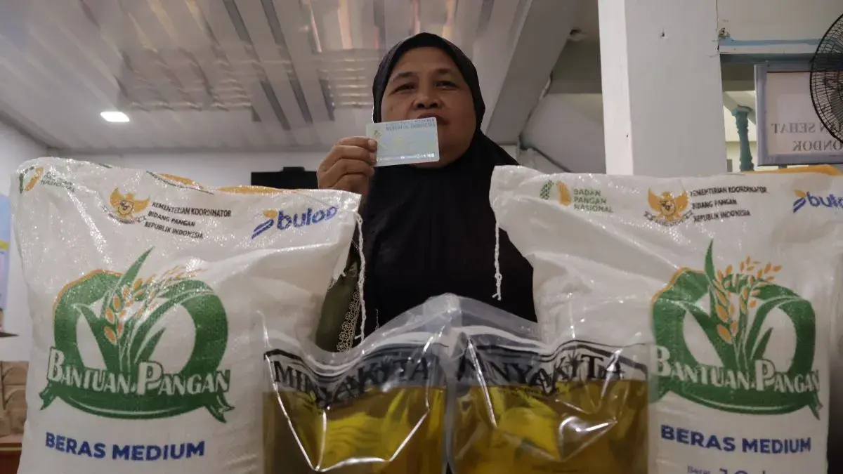 Warga mengambil bantuan sosial berupa beras dan minyak goreng yang disalurkan Pemerintah Kota Padang, Sumatera Barat. ANTARA/Muhammad Zulfikar
