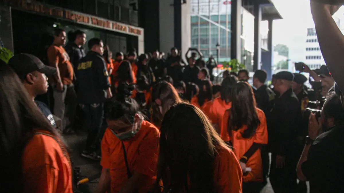 Sejumlah tersangka judi online (judol) dikawal ketat oleh aparat Kepolisian keluar dari Hayam Wuruk Tower, Jakarta, Minggu (10/05/2026). Tim gabungan Bareskrim Polri dan Polda Metro Jaya mengamankan 321 orang yang terdiri 321 WNA yang diamankan, terdiri dari 57 WN Tiongkok atau China, 228 WN Vietnam, 11 WN Laos, 13 WN Myanmar, 3 WN Malaysia, 5 WN Thailand, 3 WN Kamboja. Para pelaku ditangkap tangan saat melakukan judi online. Mereka dipindahkan secara bertahan untuk menjalani pemeriksaan lebih lanjut di Kantor Imigrasi Jakarta. (HANUNG HAMBARA/JAWA POS)