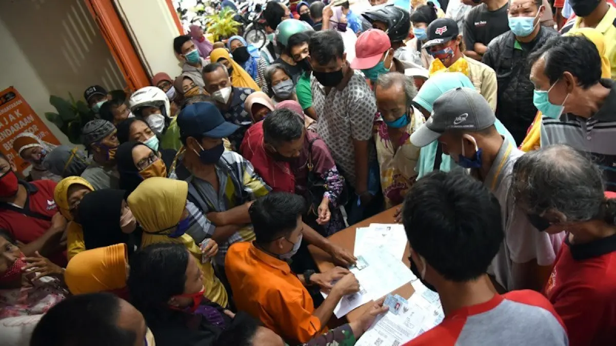 ILUSTRASI: Para penerima bansos mengantri menunggu giliran di panggil di kantor Pos Banyuwangi. (Istimewa)