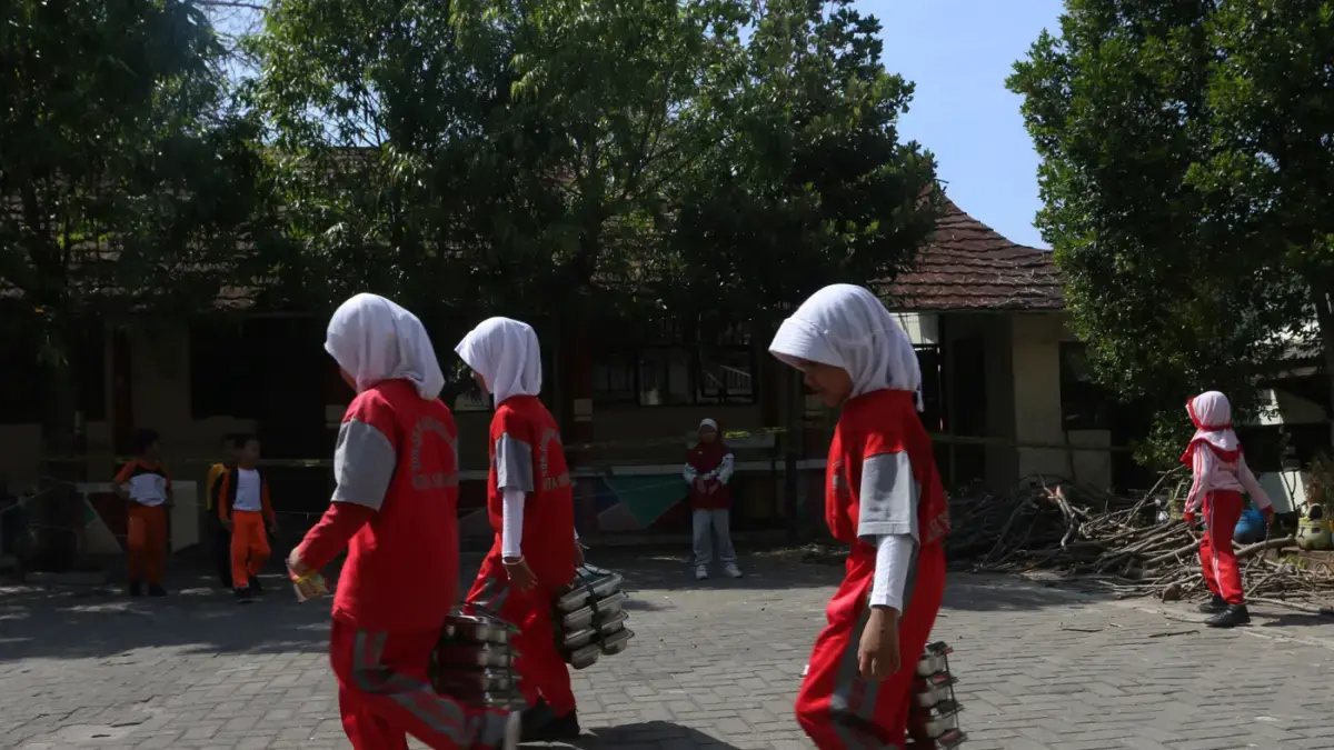 Murid bertugas membawa MBG Melintas di ruang kelas yang rusak di SD Negeri Sendangmulyo 03, Tembalang, Semarang, Jawa Tengah, Selasa (28/7/2026). (Nur Chamim/Jawa Pos Radar Semarang)