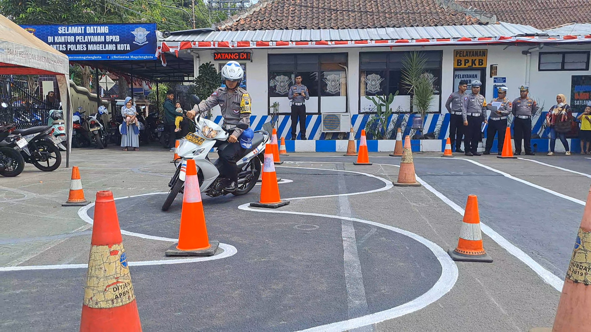 Anggota Satlantas Polres Magelang memberikan contoh uji praktik SIM C lintasan baru, Senin (7/8/2023).
