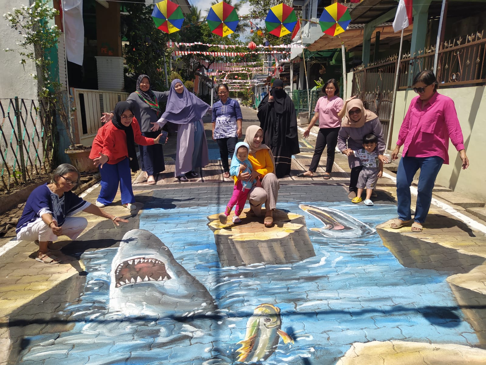 Ibu-ibu warga Gang Senggol Bumi Prayudan foto di antara lukisan 3 dimensi karya warganya.