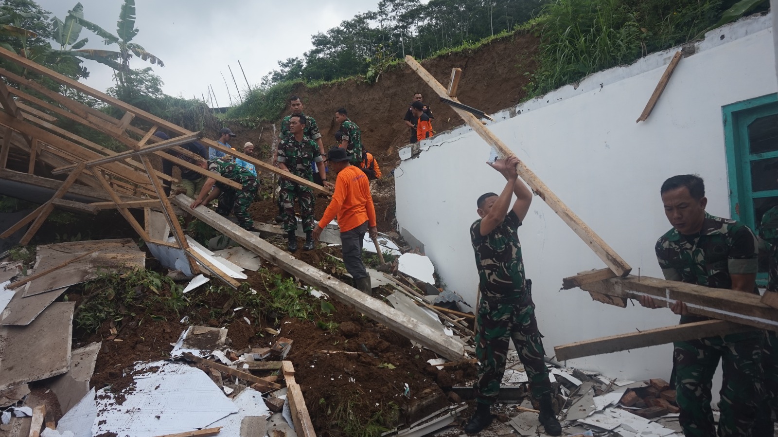 Warga bersama petugas dan TNI membenahi longsor yang menimpa Masjid Syarif Hidayatullah Kejiwan, Wonosobo