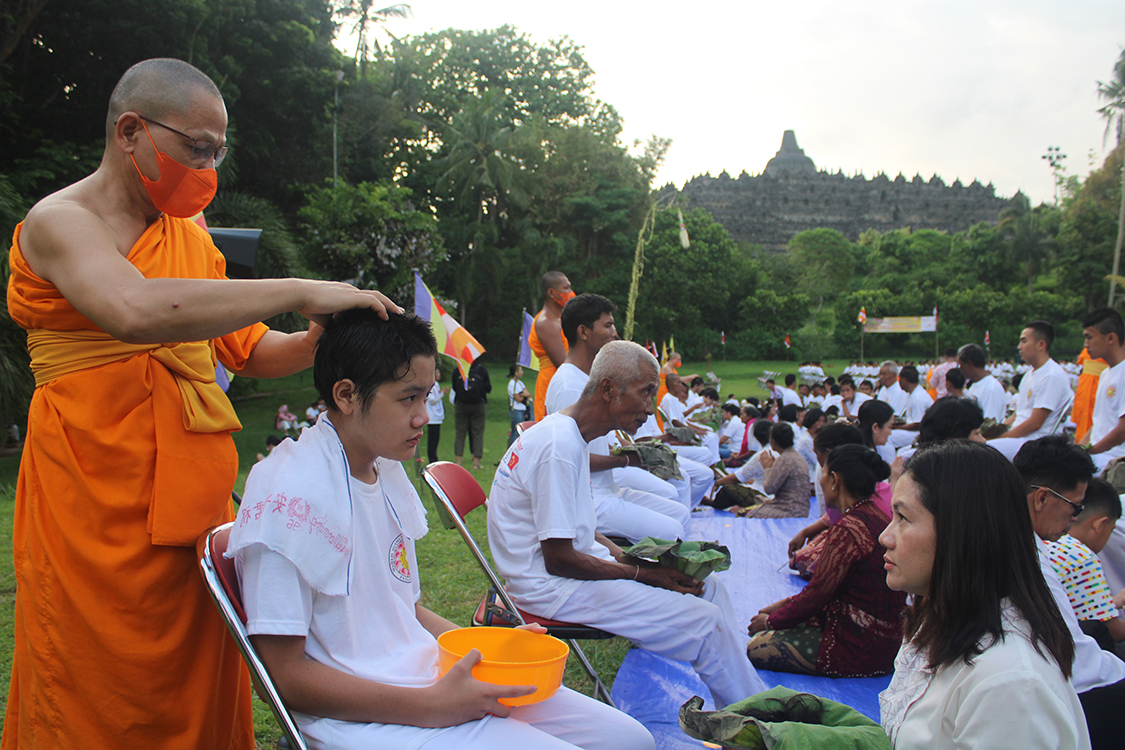 Prosesi potong rambut sebelum menjalani Pabbajja Samanera Sementara di Taman Aksobya, Candi Borobudur pada Minggu (17/12/2023) sore.
