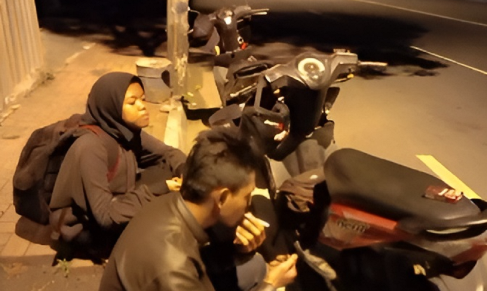 Pasangan suami istri yang ban motornya bocor.