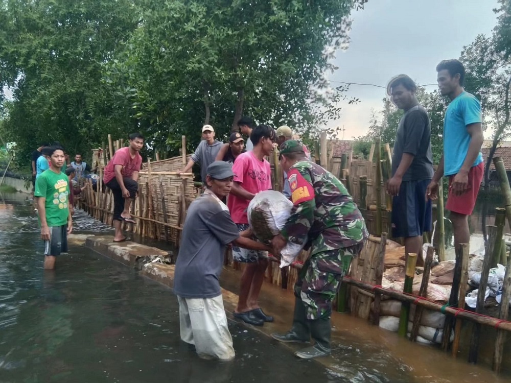 Warga bersama TNI saat berupaya menambal Tanggul Sungai Bremi-Meduri di Desa Jeruksari, Kecamatan Tirto, Kabupaten Pekalongan dengan material seadanya.