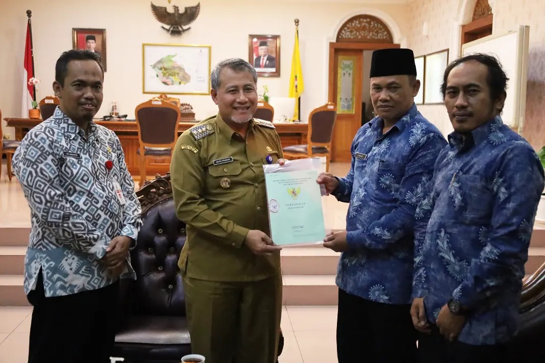 Penjabat Bupati Temanggung Hary Agung Prabowo didampingi Kepala BPKPAD menyerahkan sertifikat tanah kepada Kades Sanggarahan, Jauhari.