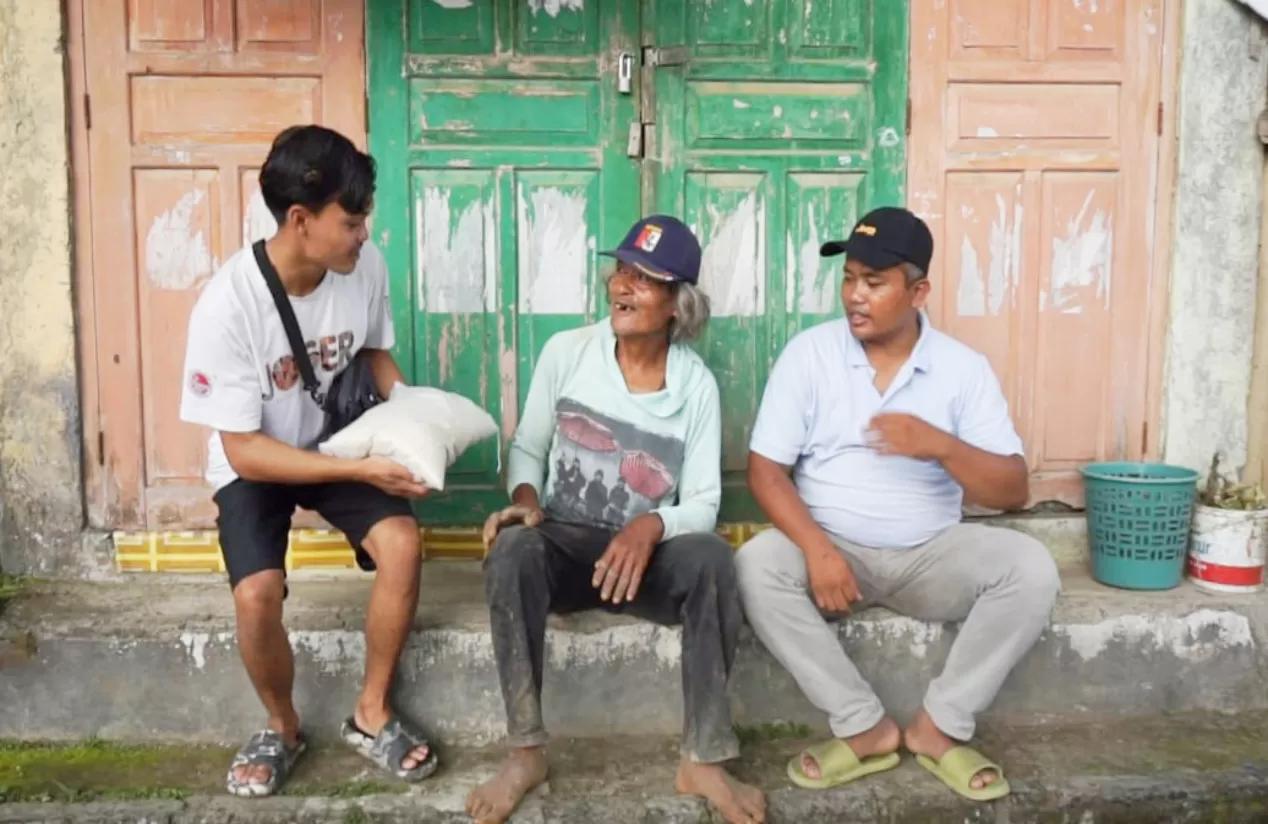 Kades Badarudin (paling kanan) bertemu warga membagikan beras hasil panen dari tanah bengkoknya.