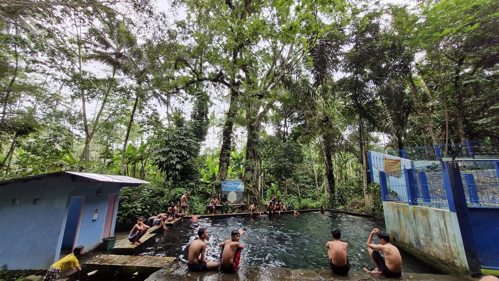 Pengunjung Sendang Maren Kecamatan Sawangan, Kabupaten Magelang terlihat sedang menghangatkan badan setelah berendam cukup lama di dalam kolam, Senin (11/3/2024).