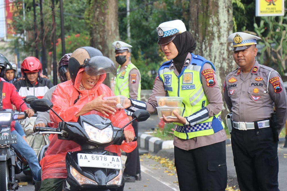 Petugas Satlantas & Bhayangkari Cabang Polres Magelang Kota membagikan 500 takjil kepada pejalan kaki maupun pengendara sepeda motor dan sopir angkot di Jalan Raya Alun-Alun Selatan, Rabu (13/3/2024)