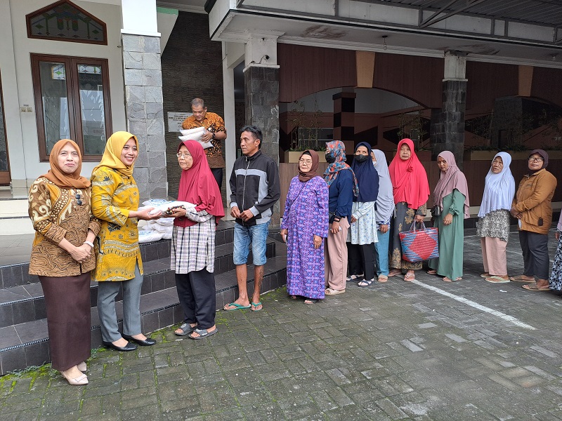 Direktur PT BPR Bank Bapas 69 Magelang Rohmad Widodo bersama Diyah Retno Andriyani dan Heni Astuti membagikan beras kepada masyarakat, Jumat (15/3/2024).