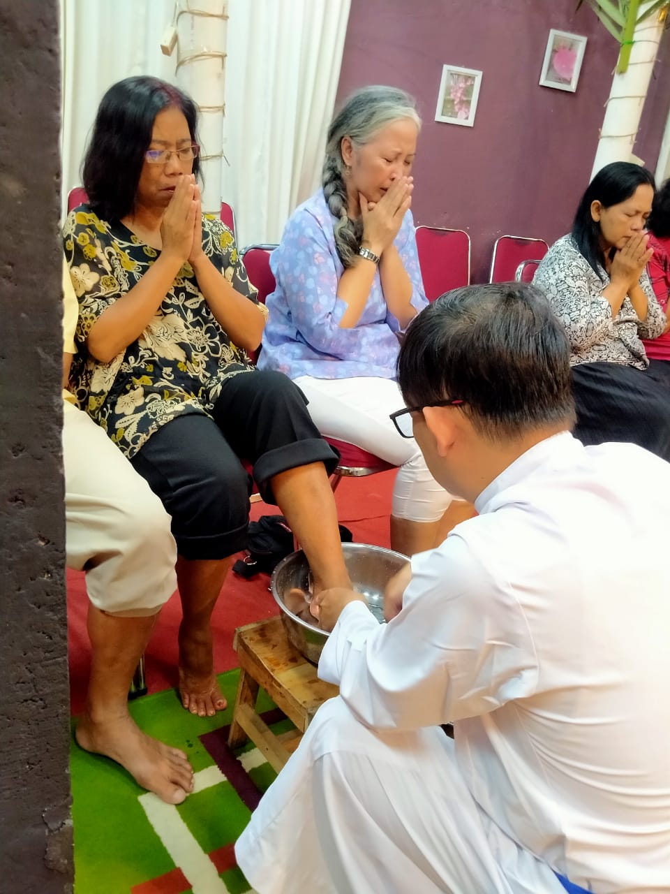Pastor Gereja Kristus Raja Magelang membasuh kaki jemaat, meneladani Yesus membasuh kaki murid-muridnya.