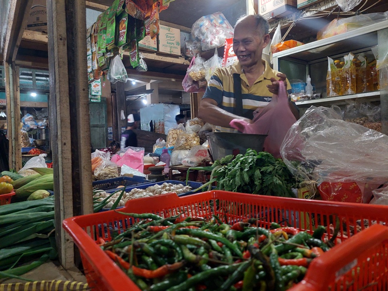 Pedagang di Pasar Kliwon Temanggung Ahmad Sugiarto menimbang cabai yang dibeli, Senin (15/4/2024).