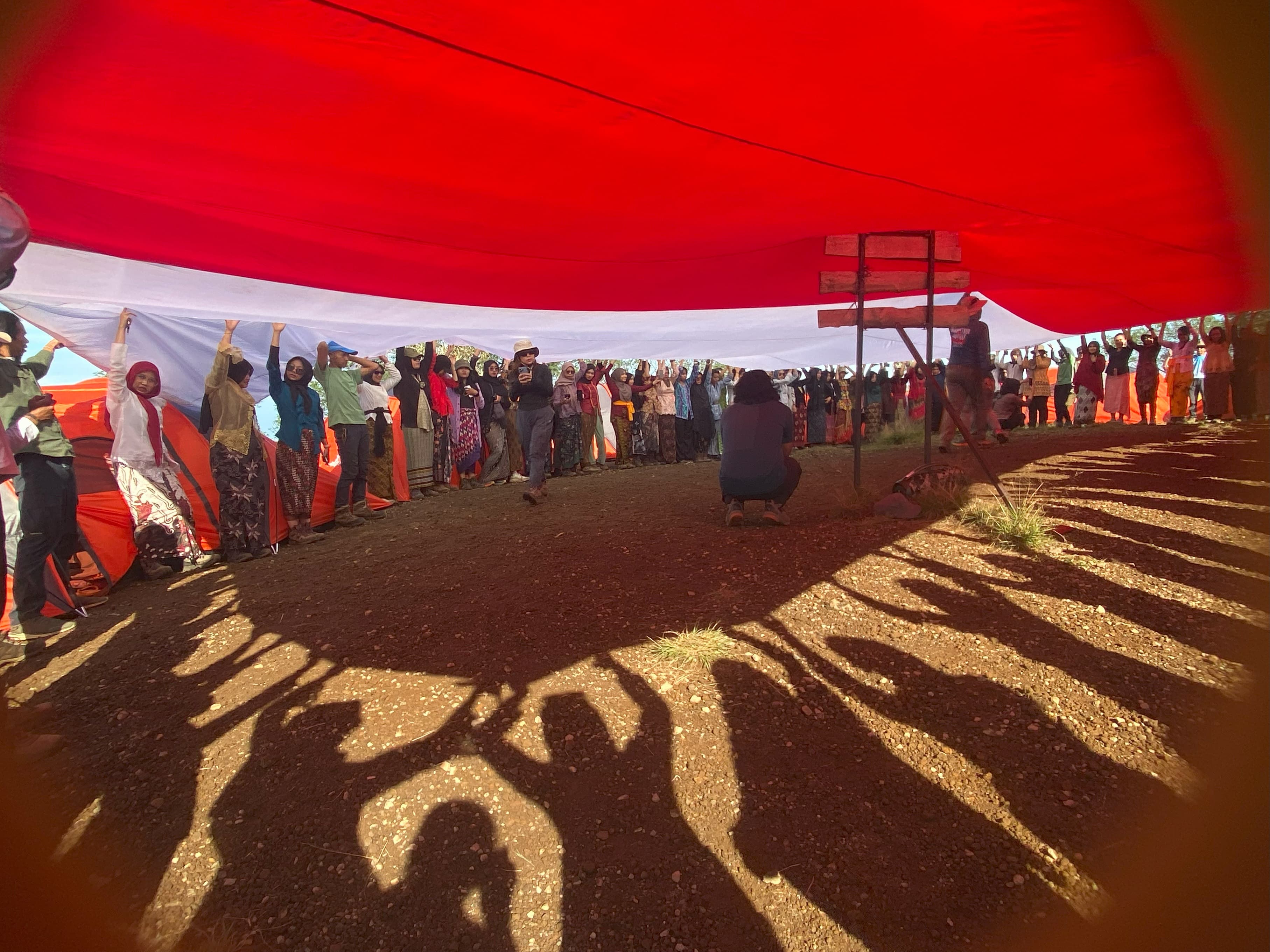 Ratusan perempuan membentangkan bendera merah putih di atas Gunung Kembang dengan kostum kebaya, Minggu (21/4/2024).