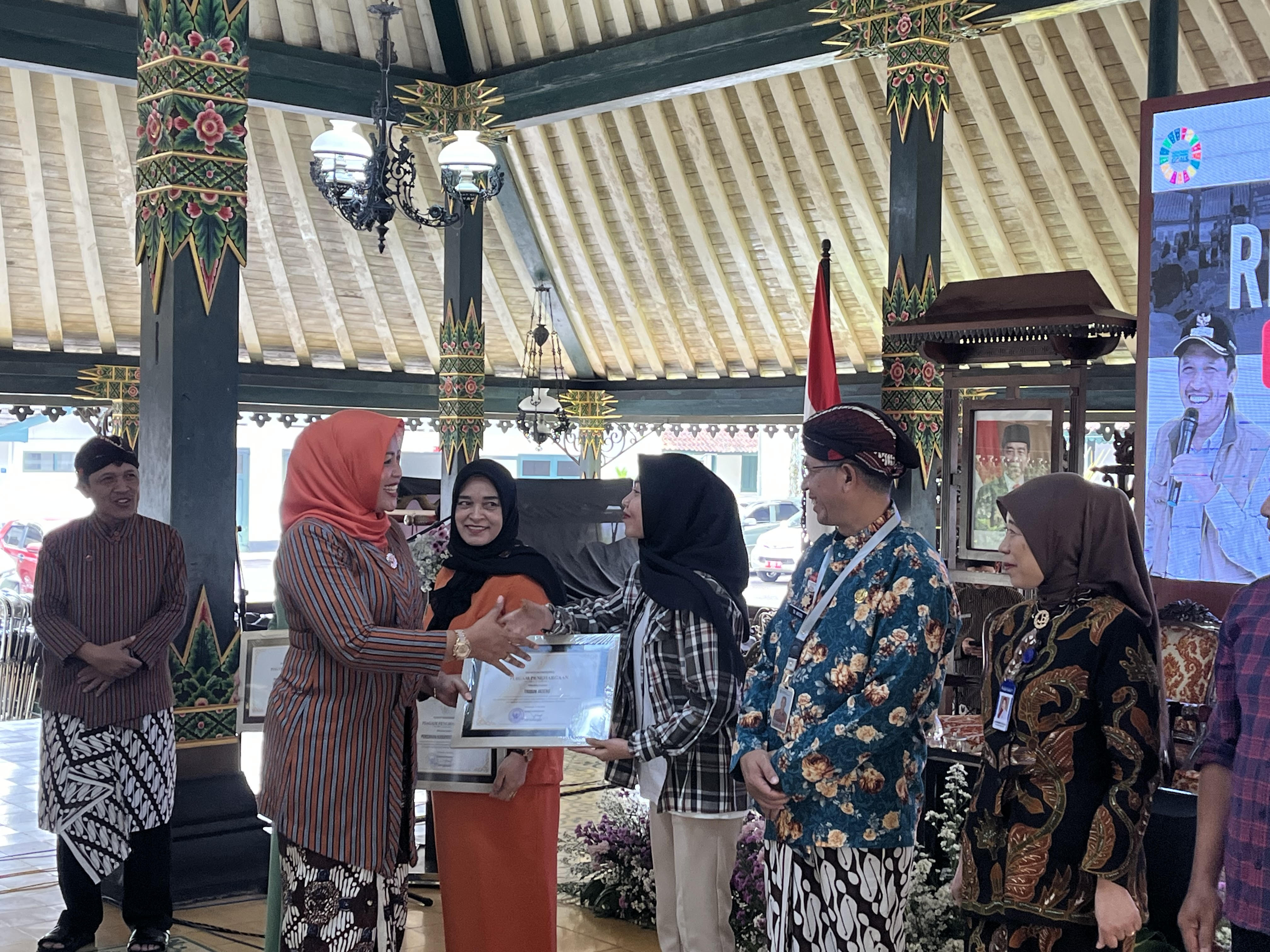 Kepala Dinas Pengendalian Penduduk, Keluarga Berencana, Pemberdayaan Perempuan & Perlindungan Anak (DPPKBPPPA) Wonosobo Dyah Retno Sulistiyowati  menyerahkan penghargaan pada acara Rembuk Stunting.
