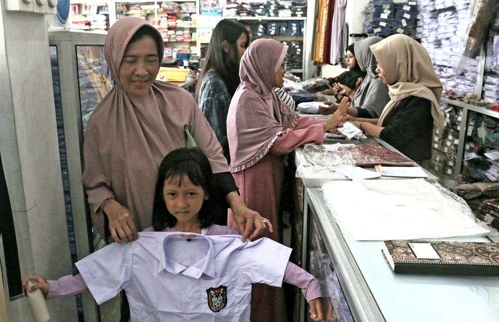 Para orang tua membelikan seragam sekolah baru untuk anaknya di Toko Bang Amat, Senin (8/7/2024).