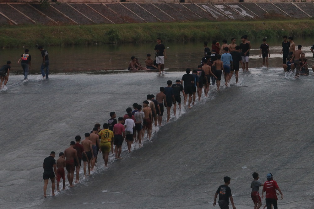 Puluhan anak bermain surfing atau seluncur di Bendungan Pleret, Sungai Banjir Kanal Barat, Kota Semarang. Pemkot Semarang mengimbau agar tetap waspada.