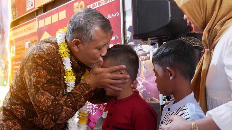 Penjabat Bupati Temanggung Hary Agung Prabowo mencium anak yatim yang menerima santunan dari pedagang Pasar Legi Parakan, Selasa (16/7/2024).