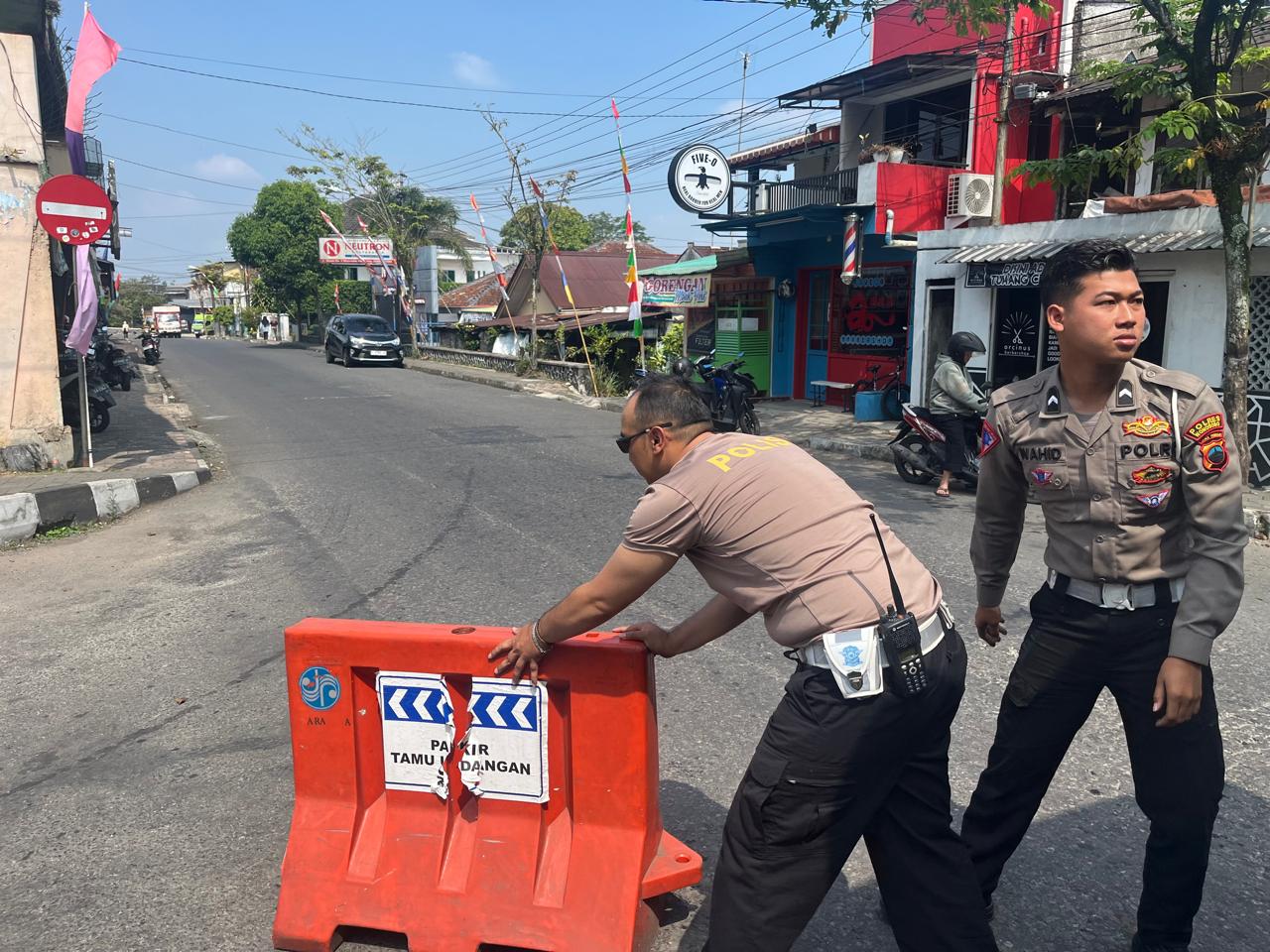 Petugas kepolisian saat akan menutup portal untuk pengalihan arus di perempatan jalan A Yani, Wonosobo, Sabtu (27/7/2024),