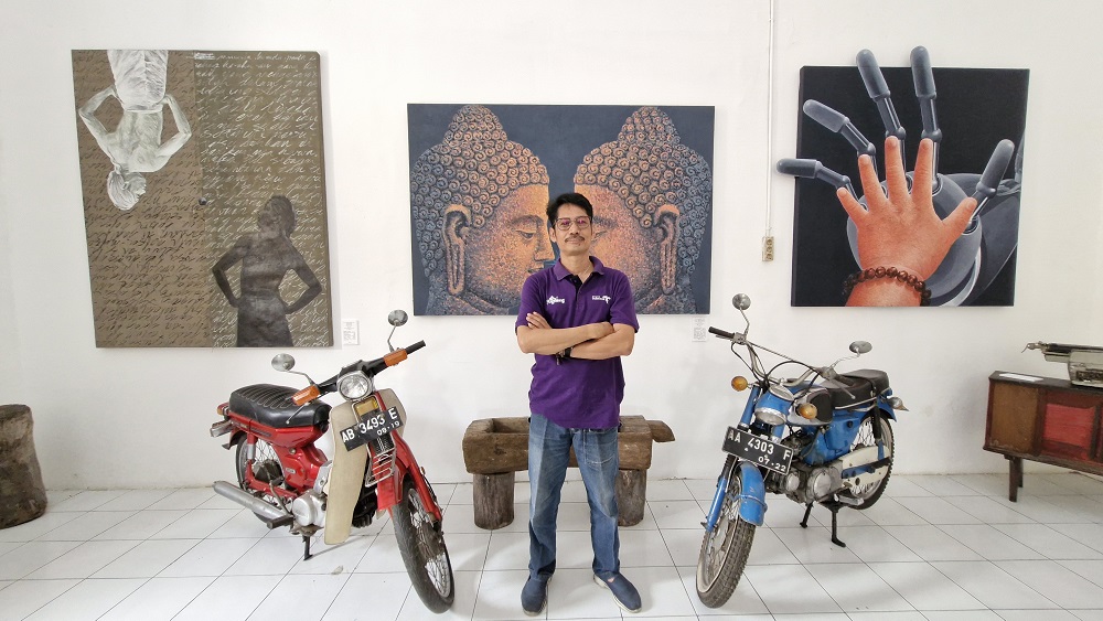 Wahudi berfoto di depan lukisannya yang dipamerkan di Mosvia Cofee, gedung Polres Magelang Kota.