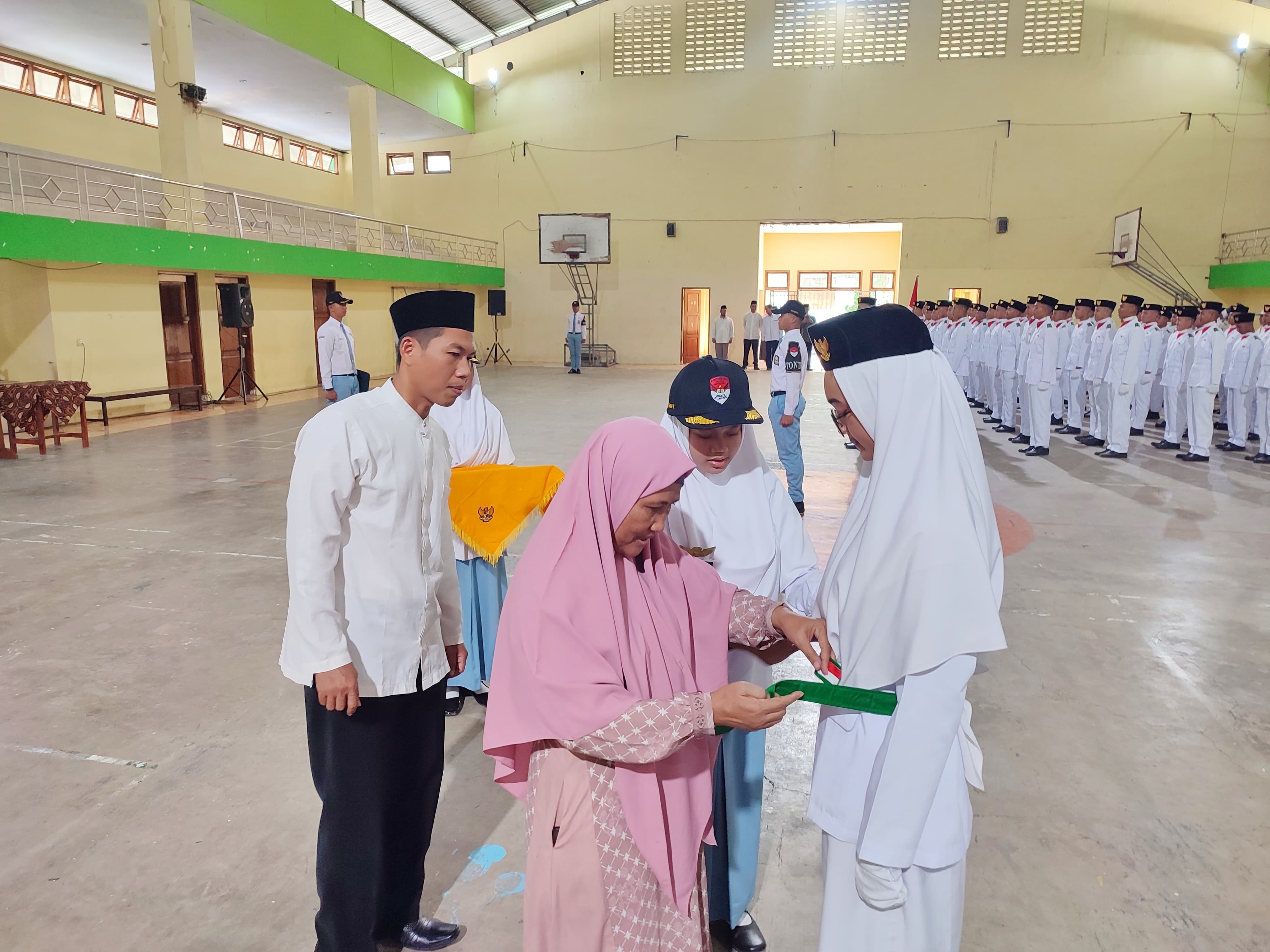 Kepala SMAIT Ihsanul Fikri Nur Cahyo Hidayati memasangkan sabuk kepada anggota Paskibrakan SMPIT-SMAIT Ihsanul Fikri di GOR H. Asy&rsquo;ari, Jumat (16/8/2024).