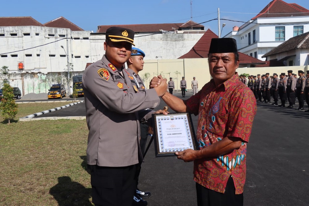 Kapolres Magelang Kota AKBP Dhanang Bagus Anggoro memberikan penghargaan kepada Yudi Ardiyanto atas dedikasinya menjaga keamanan dan ketertiban kampung, Selasa (20/8/2024).