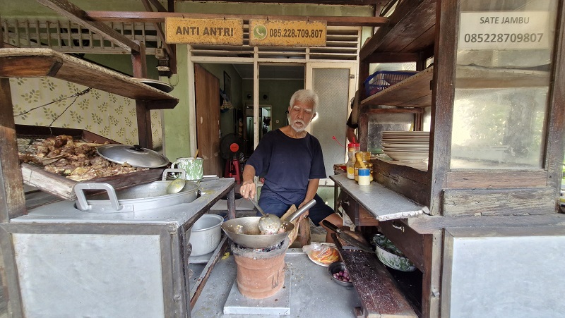 Kardiman, pemilik Sate Jambu Muntilan, sedang memasak tengkleng goreng.
