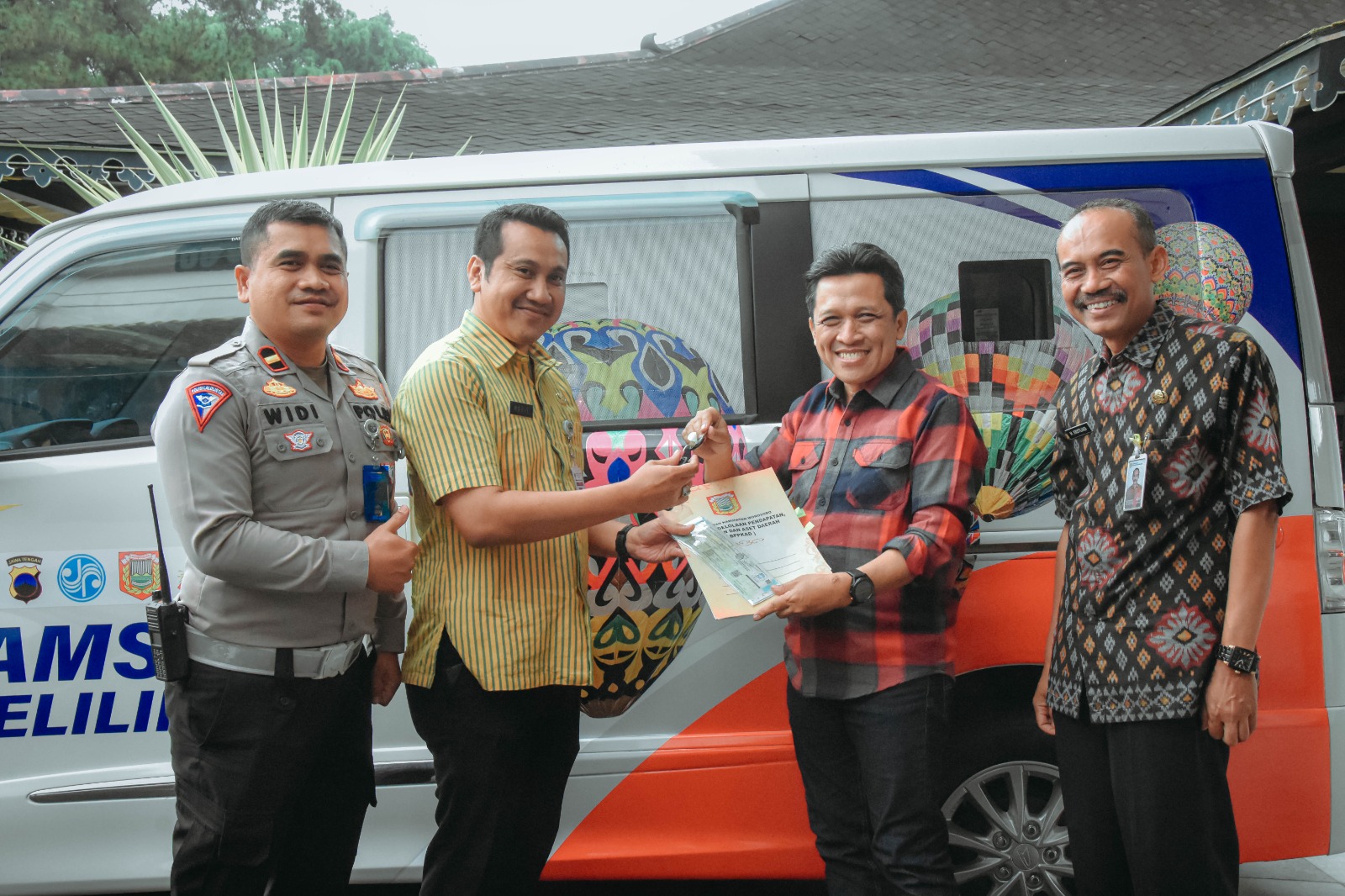 Bupati Wonosobo Afif Nurhidayat menyerahkan dokumen penyerahan mobil layanan keliling kepada Samsat.