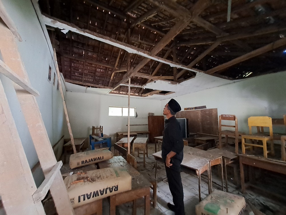 Guru MI Sirojul Munir Desa Tanjungsari, Kecamatan Windusari, Kabupaten Magelang menunjukkan ruang kelas yang plafon atapnya sudah roboh, sehingga ruang kelas tidak bisa digunakan untuk belajar