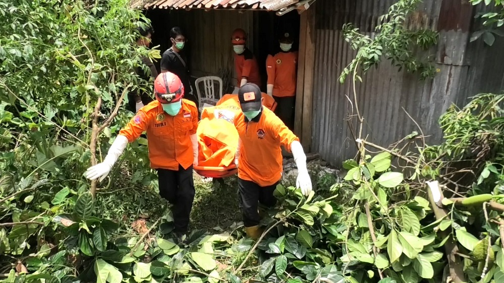 Petugas mengevakuasi jenazah Sis Hadi alias Sis Sukro dari kandang kambing.