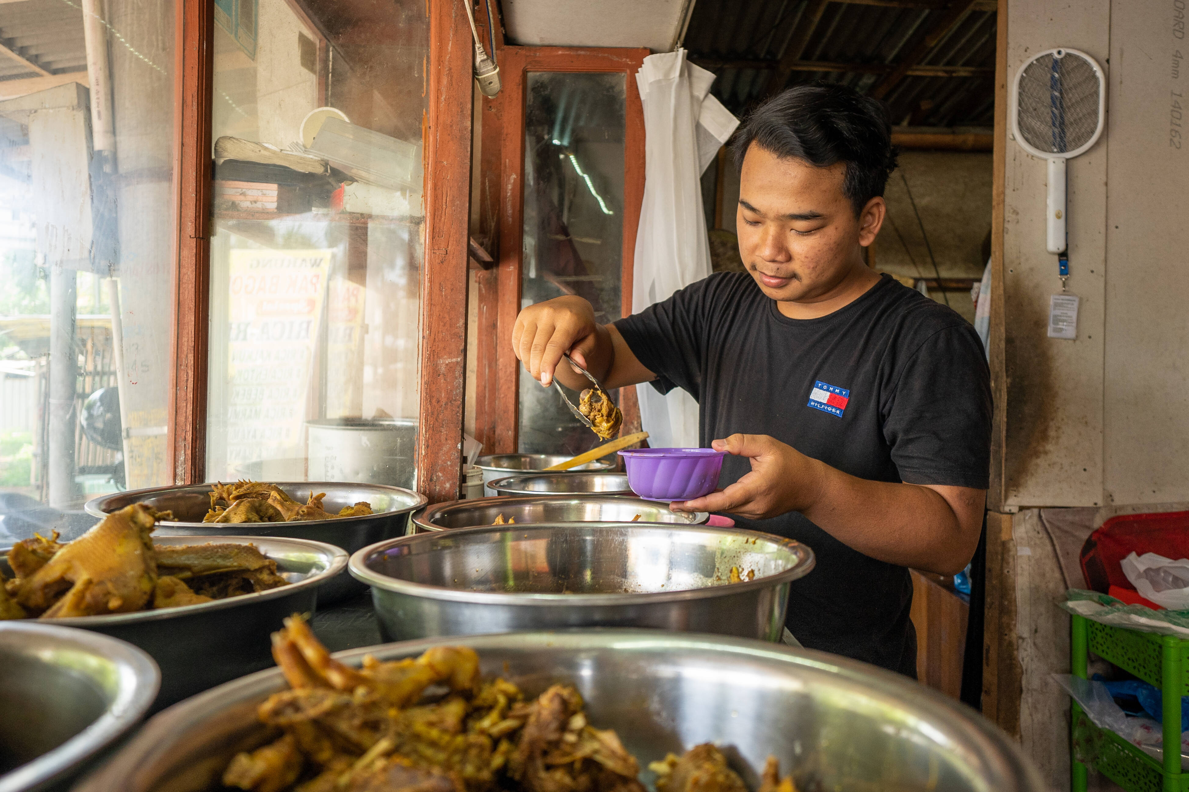 Danang Prasetyo anak Pak Bagong pemilik warung makan sibuk menyiapkan pesanan.