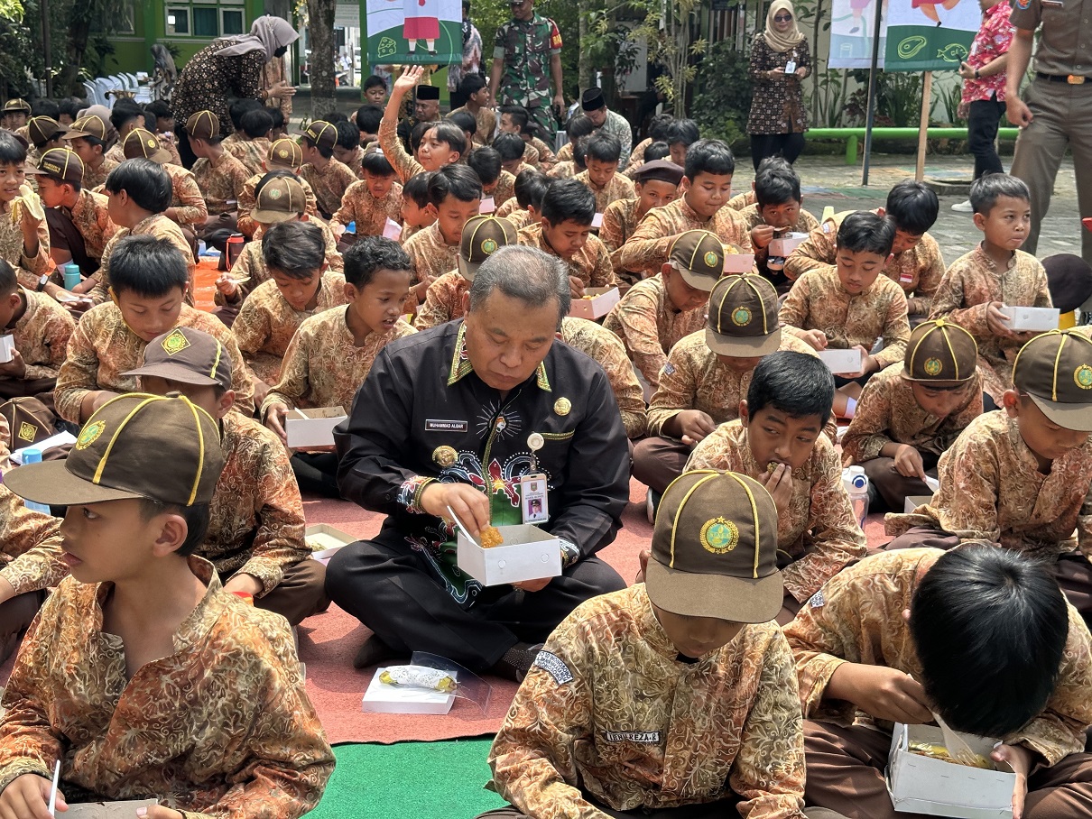 Siswa SDN 10 Wonosobo menikmati menu sajian pertama di program makan siang bergizi gratis yang diberikan oleh pemerintah, Jumat (8/11/2024) didampingi Plt Bupati Wonosobo Muhammad Albar.