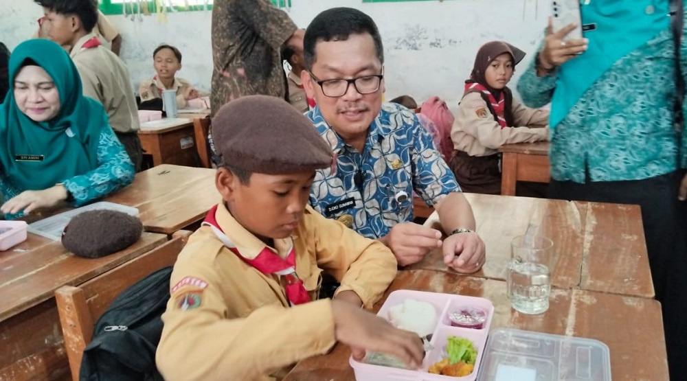 Pj Bupati Brebes Djoko Gunawan saat mendampingi siswa makan bergizi gratis di SDN 1 Banjaranyar