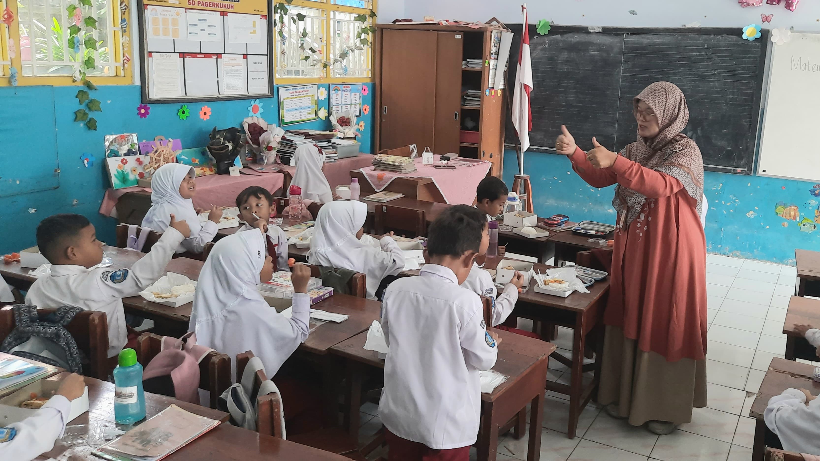 Siswa-siswi kelas 1 tengah menyantap makan siang pada uji coba Makan Siang Bergizi Gratis di SD Negeri Pagerkukuh Wonosobo, Jawa Tengah, Selasa (12/11/2024). (Ahmad Wildan Khatami/Jawa Pos)