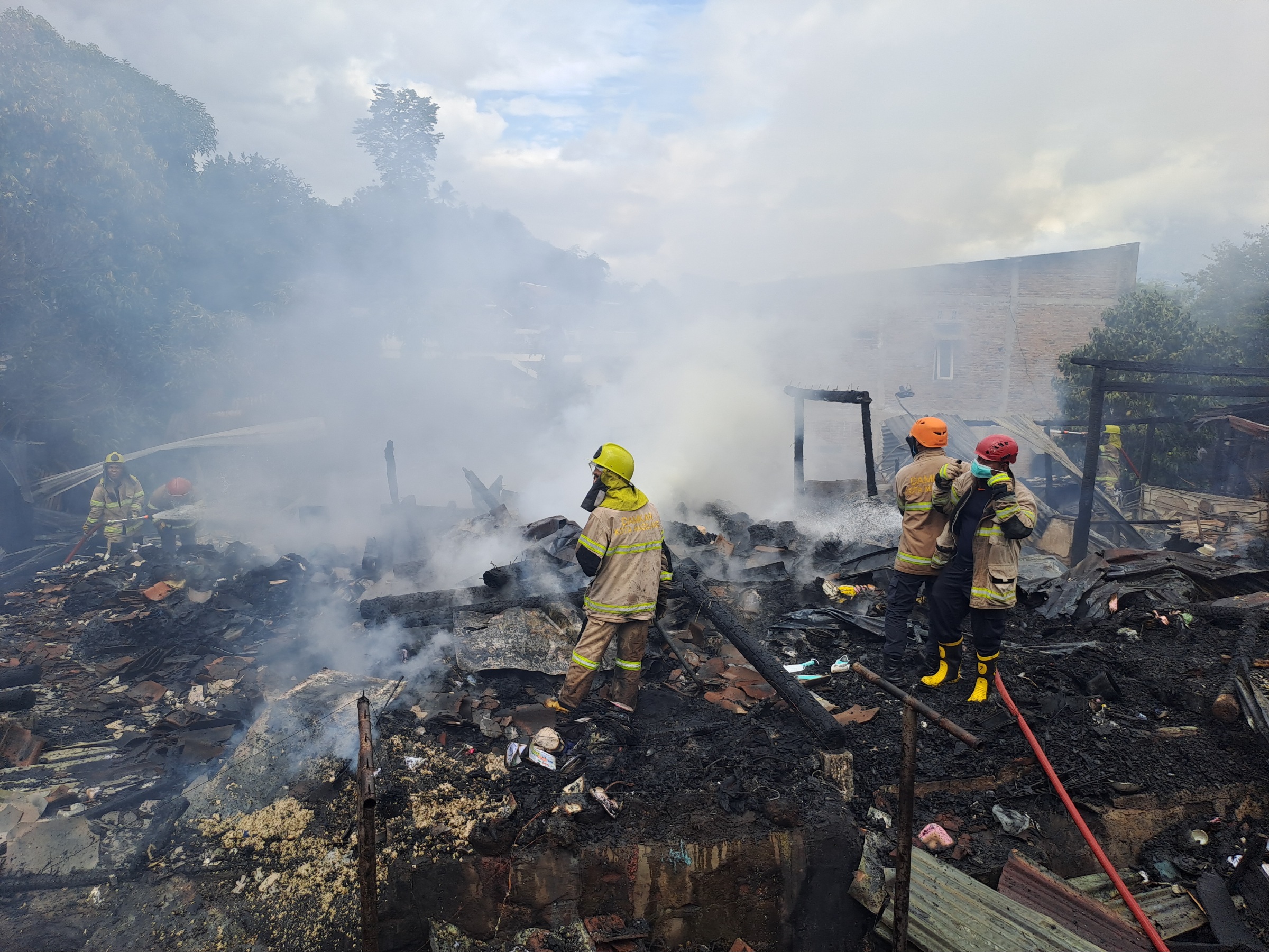 Petugas pemadam kebakaran menjinakkan api yang membakar rumah warga Cacaban, Kamis (28/11/2024).