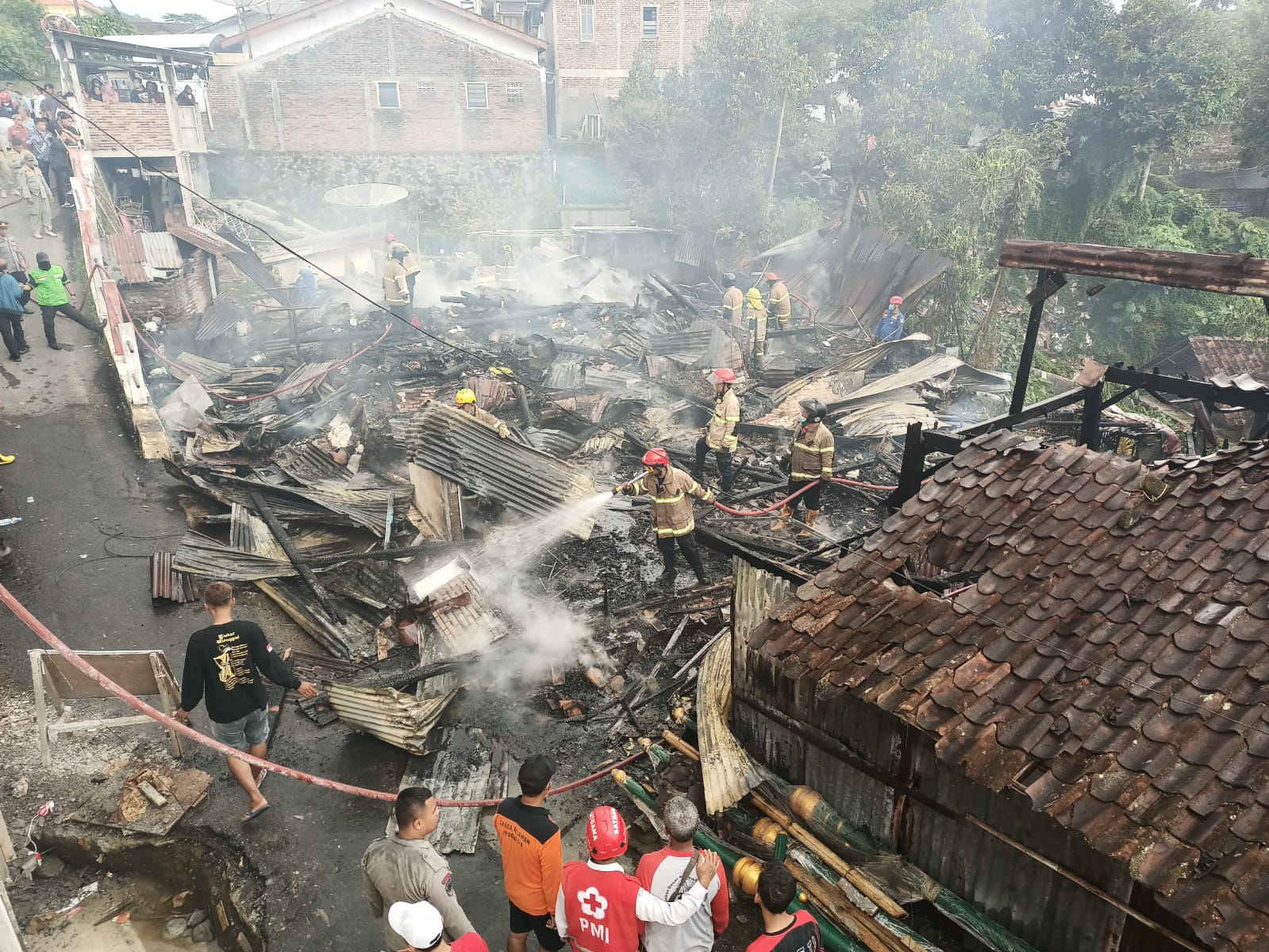 Petugas damkar yang sedang melakukan pemadaman rumah terbakar di jambon cacaban